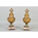 A PAIR OF LATE 19TH CENTURY GILT METAL LIDDED URNS, cast with floral swag, flaming torch and