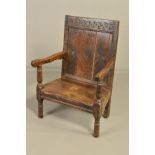 A 17TH CENTURY OAK JOINED ARMCHAIR, the rectangular back carved with a horizontal flower and