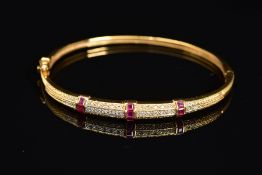 A MODERN 18CT GOLD, RUBY AND DIAMOND HALF HOOP BANGLE, an oval hinged bangle fitted to tongue and