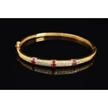 A MODERN 18CT GOLD, RUBY AND DIAMOND HALF HOOP BANGLE, an oval hinged bangle fitted to tongue and