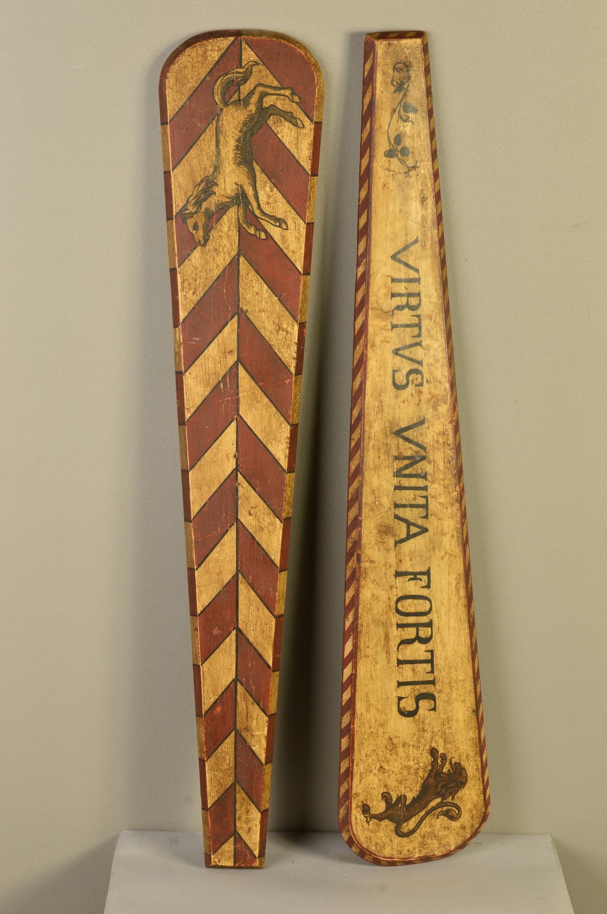 TWO ELONGATED PAINTED WOODEN PANELS, one with red and white chevrons with a rearing horse, the other