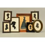 A 19TH CENTURY FULL LENGTH SILHOUETTE OF A LADY HOLDING A BOOK, mounted on paper, approximately 16.