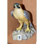 A ROYAL CROWN DERBY FALCON, standing on rocks, height 25cm