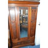 AN EDWARDIAN MAHOGANY AND FLAME MAHOGANY SINGLE MIRROR DOOR WARDROBE, above a long single drawer,