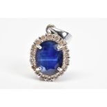 AN 18CT WHITE GOLD SAPPHIRE AND DIAMOND CLUSTER PENDANT, designed as a central oval sapphire