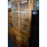 A VICTORIAN PINE GLAZED TWO DOOR BOOKCASE with two drawers, width 119cm x depth 43cm x height 211cm