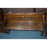 AN EARLY 20TH CENTURY OAK CHURCH PEW with carved quatrefoils to back, width 134cm