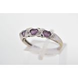 A CUBIC ZIRCONIA DRESS RING, designed as three oval purple cubic zirconias, each interspaced by a