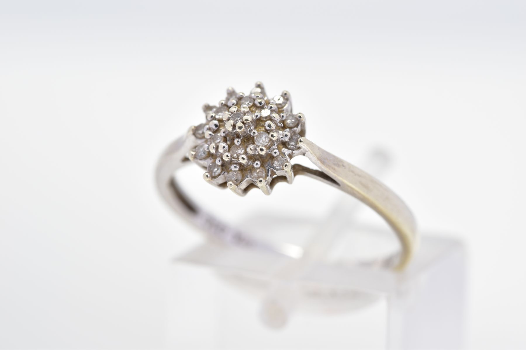 A 9CT WHITE GOLD DIAMOND CLUSTER RING, designed as a tiered single cut, claw set diamond cluster,