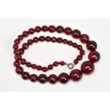 A RED PLASTIC BEAD NECKLACE, designed as graduated spherical beads measuring approximately 6mm to