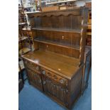 A MODERN OAK LINENFOLD DRESSER with plate rack, width 126cm x height 168cm x depth 47cm