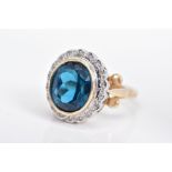 A MODERN 9CT GOLD BLUE TOPAZ AND DIAMOND OVAL CLUSTER RING, centering on an oval dark blue topaz