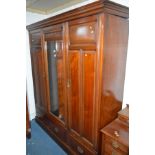 AN EDWARDIAN WALNUT THREE PIECE BEDROOM SUITE, comprising of a triple mirror door wardrobe with