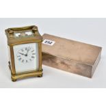 A BRASS CARRIAGE CLOCK AND A SILVER CIGARETTE BOX, the carriage clock with white face, black Roman