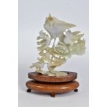 A CARVED BOWENITE FIGURE, depicting birds feeding on foliage, on a detachable wooden stand,