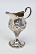 A GEORGE III SILVER CREAM JUG, of baluster form with pedestal, embossed scrolling and floral