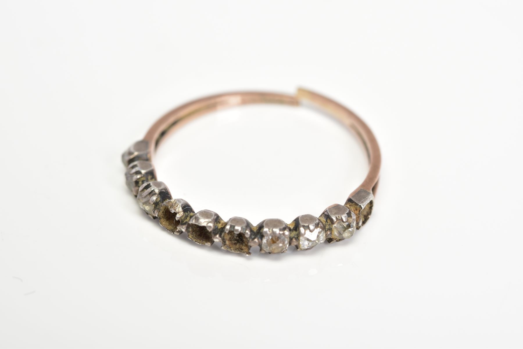 A LATE GEORGIAN DIAMOND HALF ETERNITY RING, with closed back settings for ten diamonds, set with six