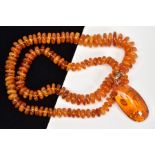 A MODIFIED AMBER NECKLACE AND PENDANT, the necklace designed as graduated disc shape beads to the