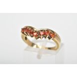 A 9CT GOLD ORANGE TOPAZ RING, the v-shape ring claw set with seven circular orange topaz stones,