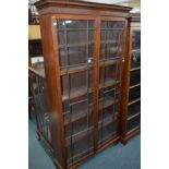 AN EDWARDIAN MAHOGANY TWO DOOR ASTRAGAL GLAZED BOOKCASE standing on bracket feet, width 103cm x