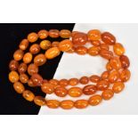 A NATURAL AMBER BEAD NECKLACE, fifty fine oval beads graduating in size from 9mm x 5.5mm to 16mm x