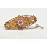 AN EARLY 20TH CENTURY 9CT GOLD GEM SET BROOCH, of oval outline set with a central circular red gem