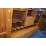 A MID CENTURY TEAK WALL UNIT BY PORTWOOD FURNITURE with two glazed doors either side of a shorter
