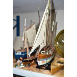 A GROUP OF SAIL BOATS ON STANDS, with a flat bottomed rowing boat and a miniature fishing boat, sail