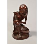 A JAPANESE HARDWOOD LAUGHING SEATED SKELETON, with part paper label to base, height 14cm