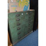AN EARLY 20TH CENTURY GREEN PAINTED PINE BANK OF TWELVE DRAWERS with brass cupped handles, width