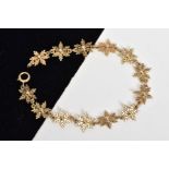 A 9CT GOLD SNOWFLAKE LINK BRACELET, made up of thirteen snowflakes with spherical centres, fitted