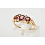 A 9CT GOLD GARNET AND DIAMOND RING, with three graduated circular cut garnets interspaced with round