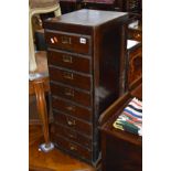 A VINTAGE STAINED PINE OFFICE CHEST of eight drawers, width 33cm x height 90cm x depth 38cm