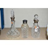 TWO CUT GLASS DECANTERS, both having silver collars, with a cut glass cocktail shaker, having silver