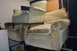 A PAIR OF EARLY 20TH CENTURY GREEN UPHOLSTERED ARMCHAIRS IN THE MANNER OF HOWARD & SONS, together