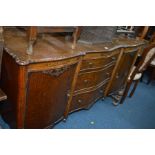 AN EARLY 20TH CENTURY OAK SIDEBOARD with a raised back, two cupboard doors flanking three