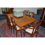 A REPRODUCTION WALNUT EXTENDING TABLE, the top with canted corners pn shell carved knee's,