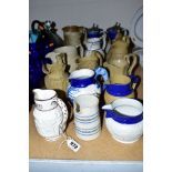 A GROUP OF SIXTEEN VICTORIAN PARIAN AND STONEWARE RELIEF MOULDED JUGS, a pair having pewter covers