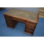 AN EARLY 20TH CENTURY CARVED OAK PEDESTAL DESK, dark green gilt tooled leather inlay top and nine