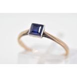 A SAPPHIRE RING, designed with a central square cut sapphire in a milegrain setting to the tapered