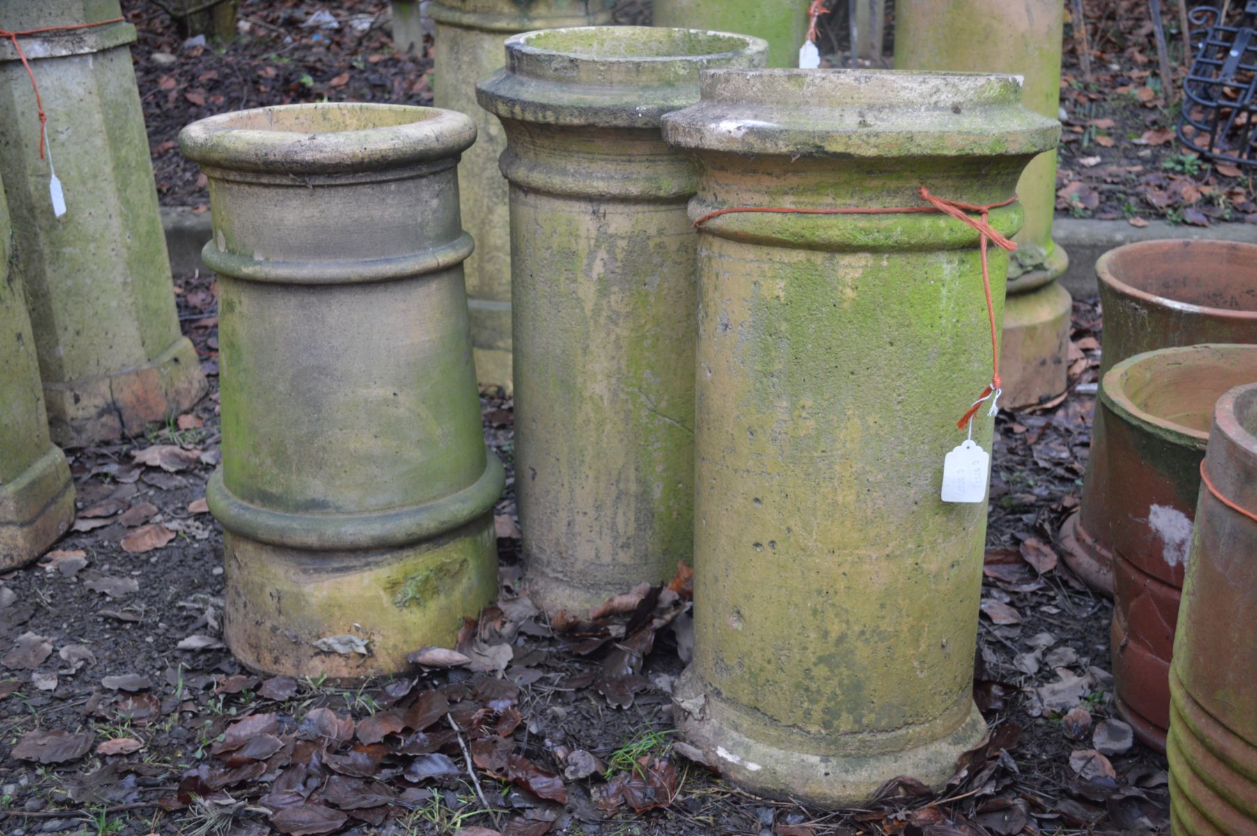 A PAIR OF CLAY CYLINDRICAL CHIMNEY POTS, height 65cm (s.d. to base of one pot), together with a