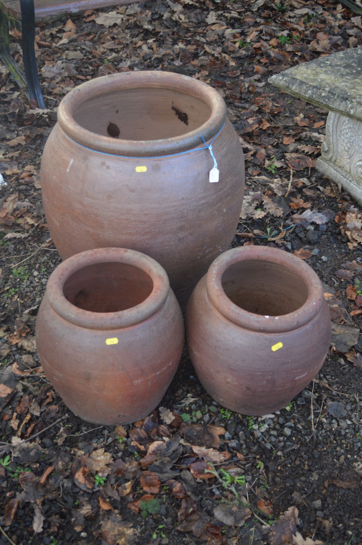 A LARGE GLAZED TERRACOTTA CYLINDRICAL PLANTER, rim diameter 42cm x height 60cm, together with two