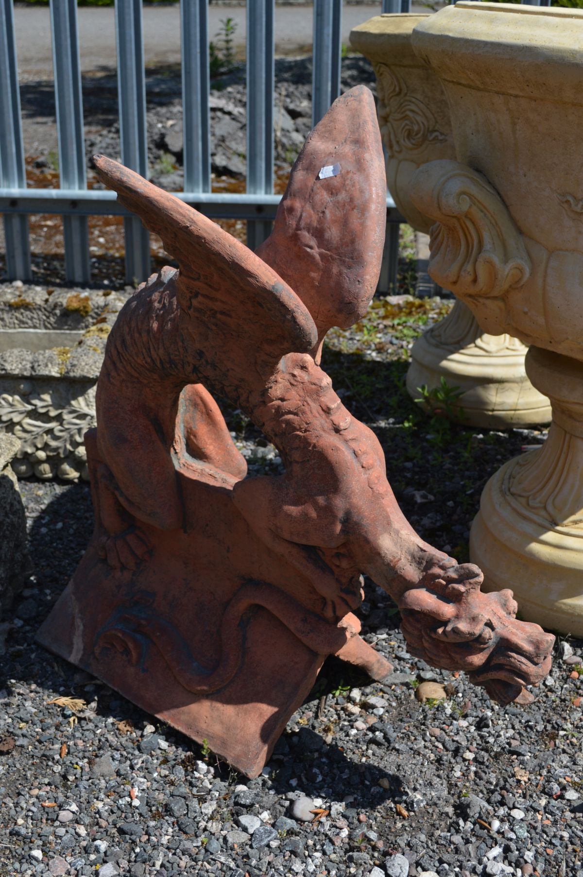 A TERRACOTTA ROOF TOP FIGURE HEAD, of a mythical dragon creature with open wings