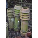 A PAIR OF CLAY CYLINDRICAL LOUVRED CHIMNEY POTS, height 117cm, together with a similar smaller