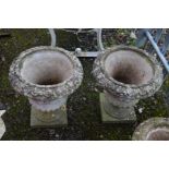 A PAIR OF COMPOSITE COMPAGNA AND FOLIATE GARDEN URNS, on separate square bases, diameter 46cm x