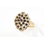 A 9CT GOLD SAPPHIRE DRESS RING, designed as an openwork panel with scalloped edge, claw set with