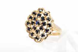 A 9CT GOLD SAPPHIRE DRESS RING, designed as an openwork panel with scalloped edge, claw set with