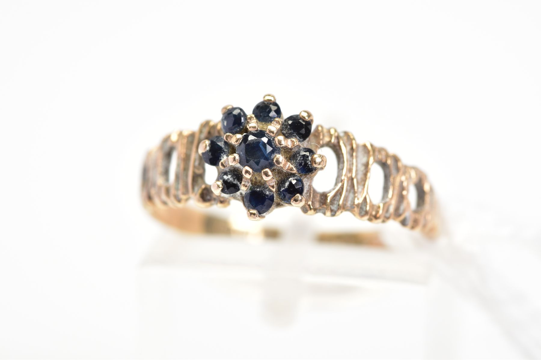 A 1970'S 9CT GOLD SAPPHIRE CLUSTER RING, the tiered cluster claw set with circular cut sapphires, to