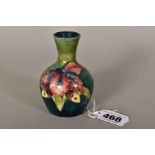A SMALL MOORCROFT POTTERY BUD VASE, 'Orchid' pattern on green ground, Queen Mary paper label to