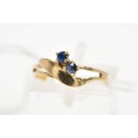 A 9CT GOLD SAPPHIRE DRESS RING, of asymmetric design and split front band, diagonally set with two